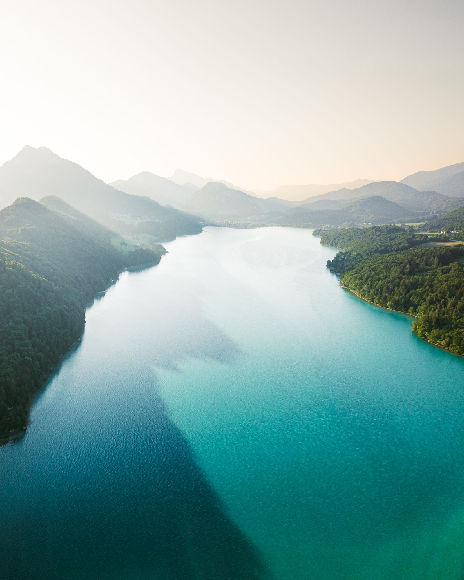 Der Fuschlsee von oben, türkises Wasser umgeben von Wald